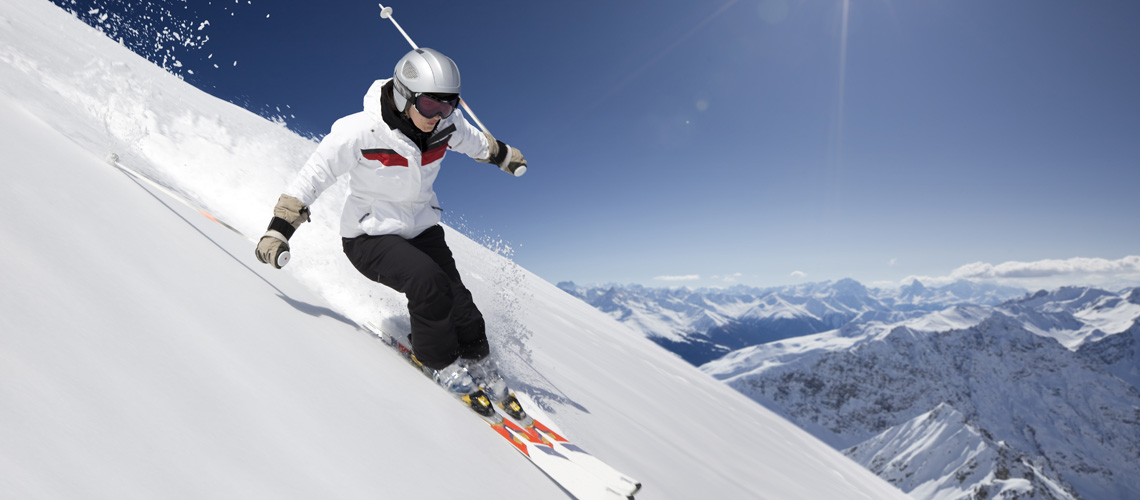 Person p skidor nerfr en brant backe