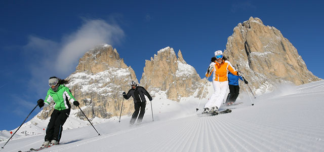 3 personer som ker skidor nerfr backen